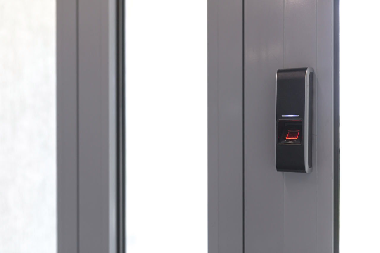 Door lock on door with fingerprint sensor, entrance to modern office and home.