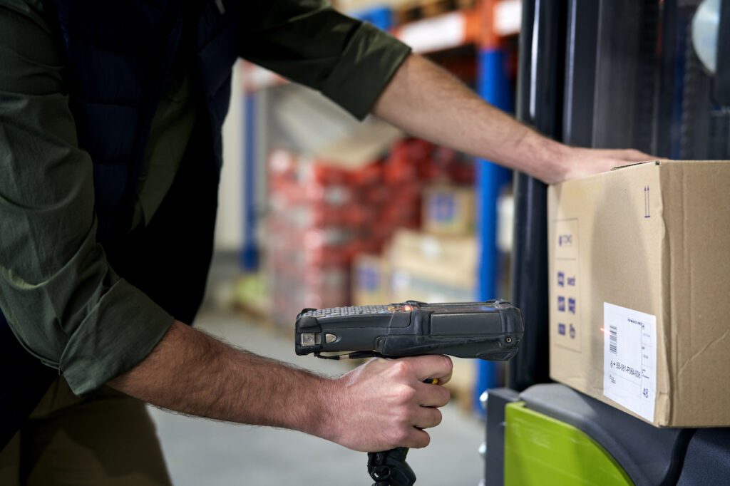 Close up of man using bar code reader in a warehouse