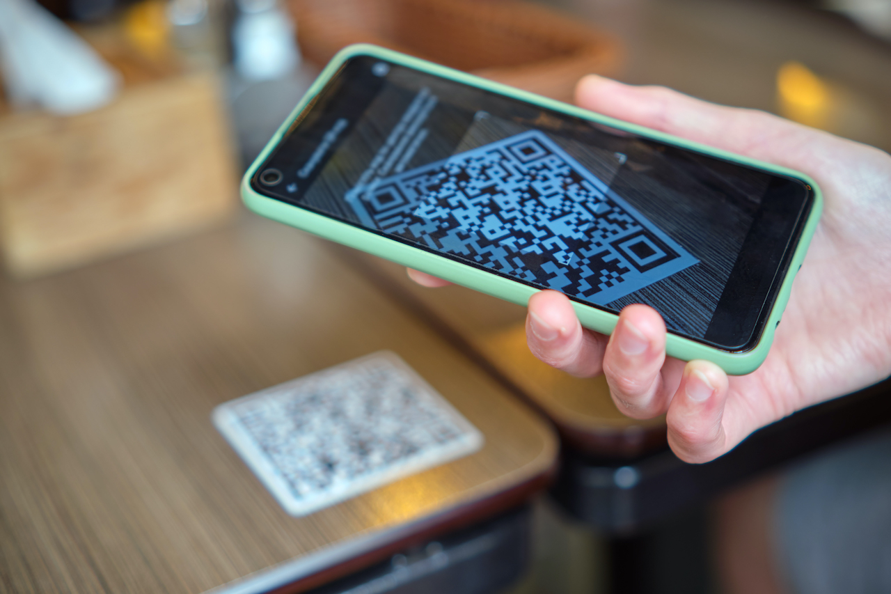 A person using a mobile phone in scanning a barcode.