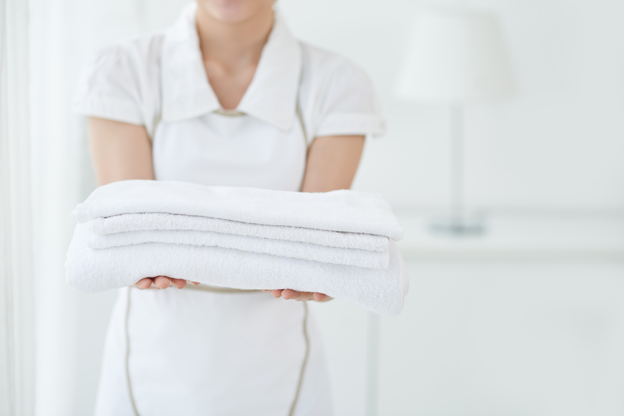 Woman holding towels for asset tracking in hotels.
