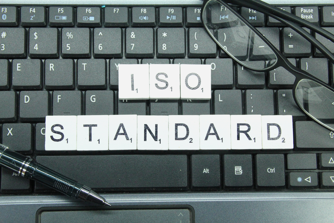 ISO standard letters from scrabble blocks placed on a keyboard