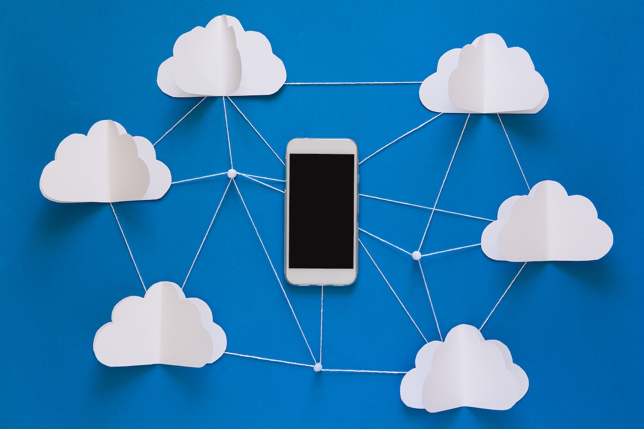 A mobile phone connected to multiple clouds to show cloud hosting.
