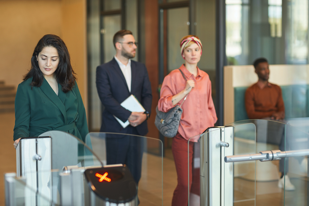 Visitors entering turnstile. Related to visitor management system.