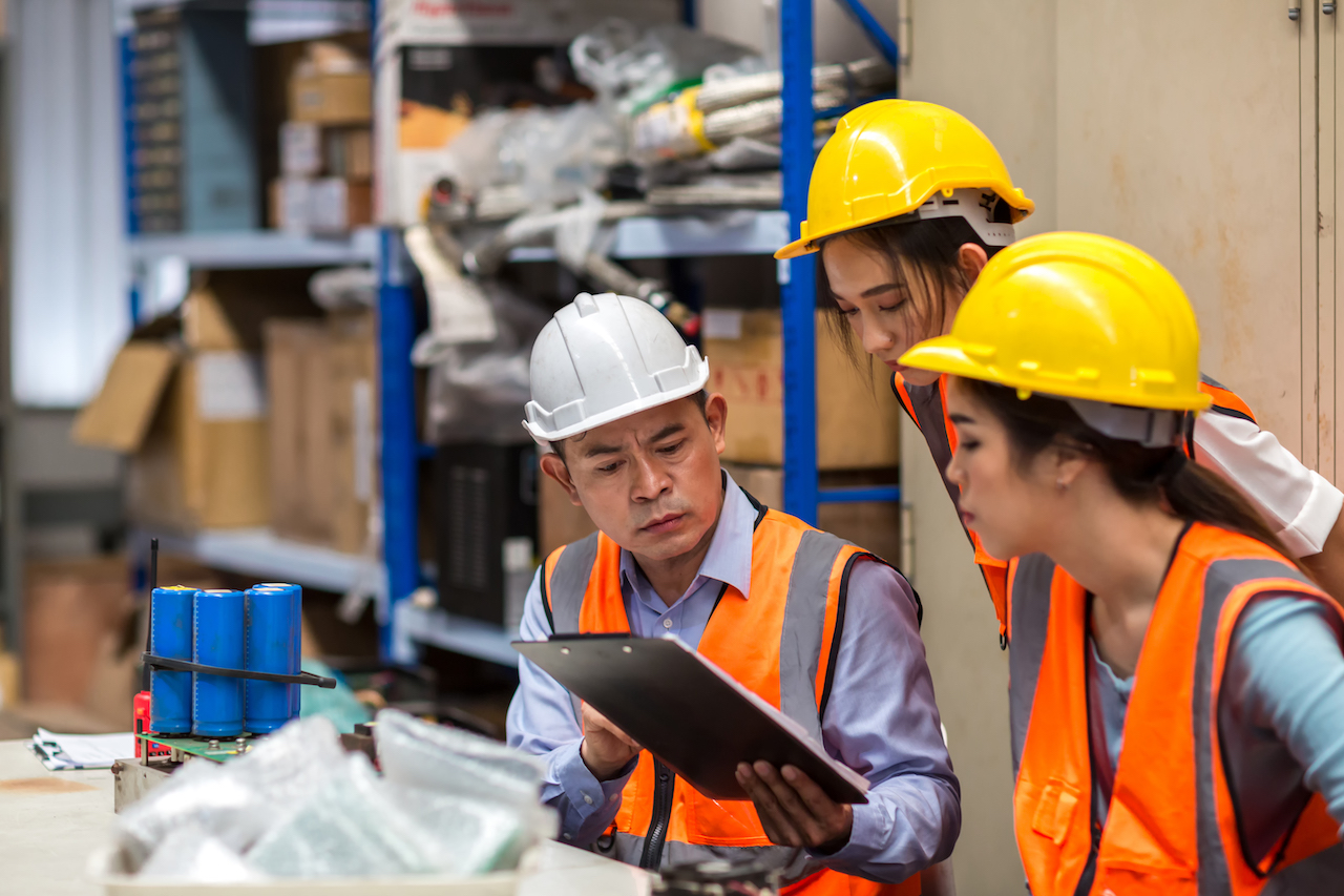 Team foreman and team workers work at a factory site doing a meeting