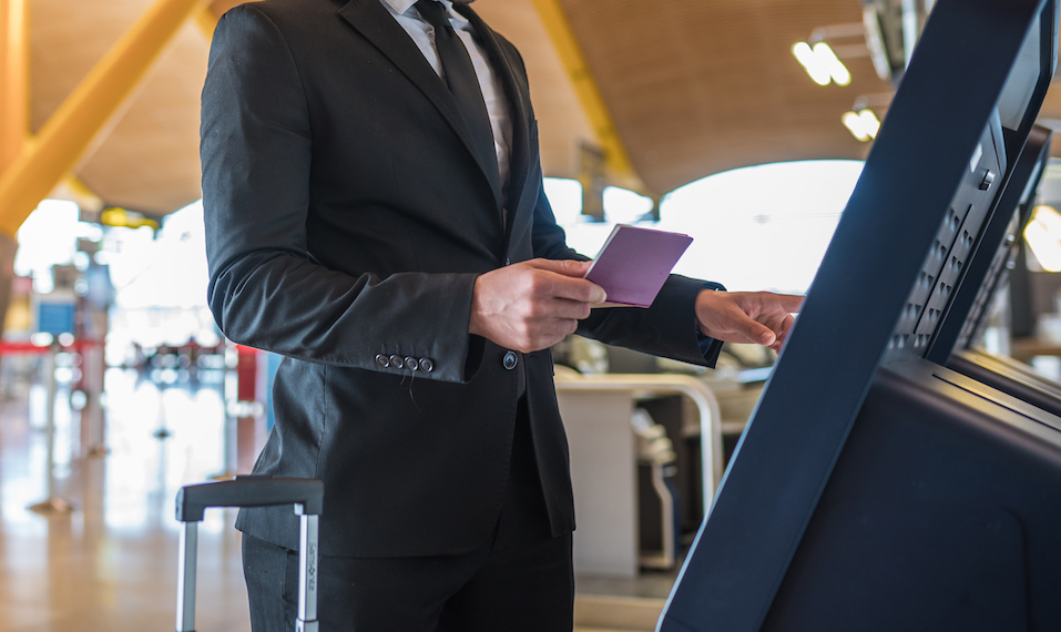 Young business man doing self check in a in a visitor management kiosk