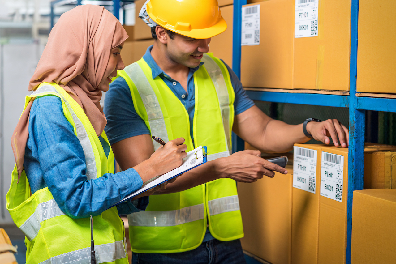 Asian Idian worker man with Muslim worker woman working together by scanning bar code and QR code in local warehouse, Partner and colleague working together, business reopening after Covid19 concept