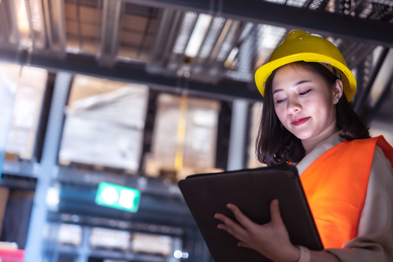 Pretty worker checking stock in the warehouse. Asian beautiful young woman worker of furniture store.Businesswoman using tablet in distribution stock.