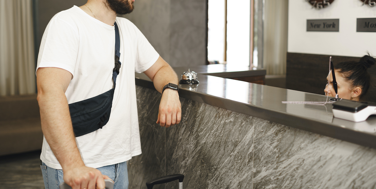 Bearded man in casual wear checks-in in a building reception