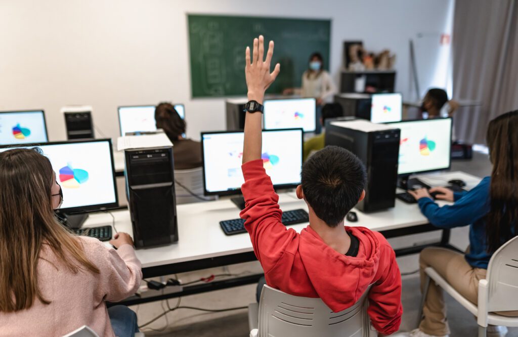 Young students listening a lesson in high school while wearing face mask during corona virus pandemic - Education and technology concept